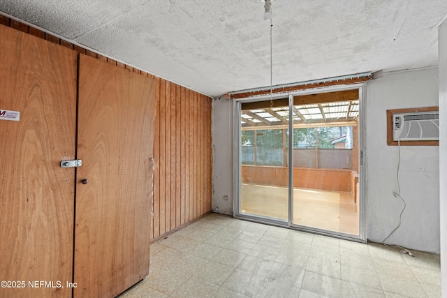 spare room with a wall mounted AC and wood walls