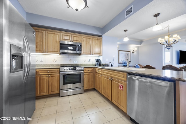 kitchen featuring light tile patterned flooring, sink, ornamental molding, appliances with stainless steel finishes, and pendant lighting