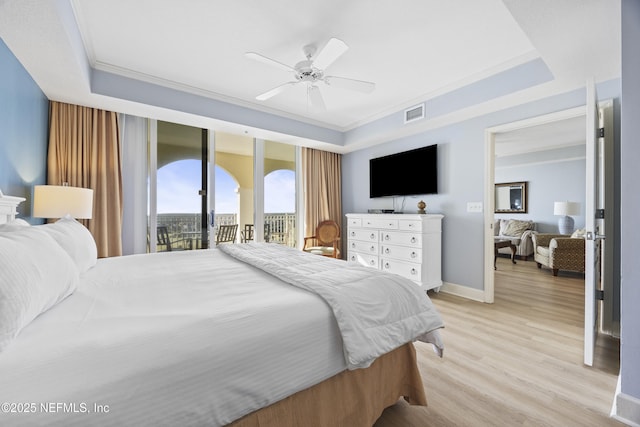 bedroom with a tray ceiling, access to outside, ceiling fan, and light wood-type flooring