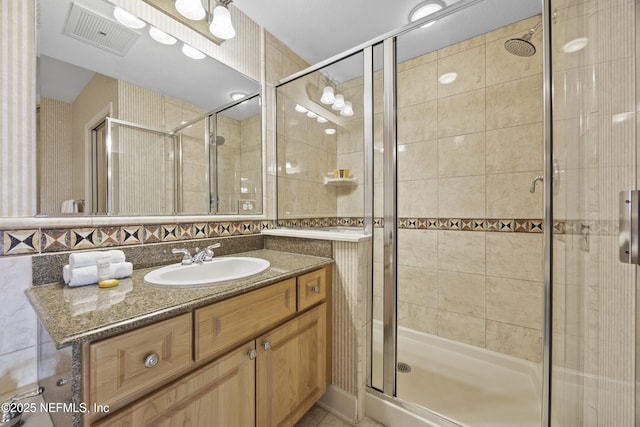 bathroom with vanity and a shower with shower door