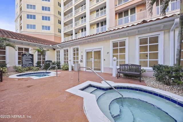 view of swimming pool with a hot tub