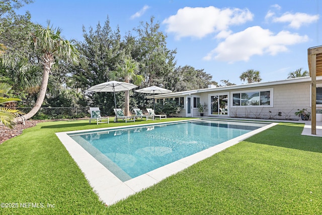 view of swimming pool with a yard