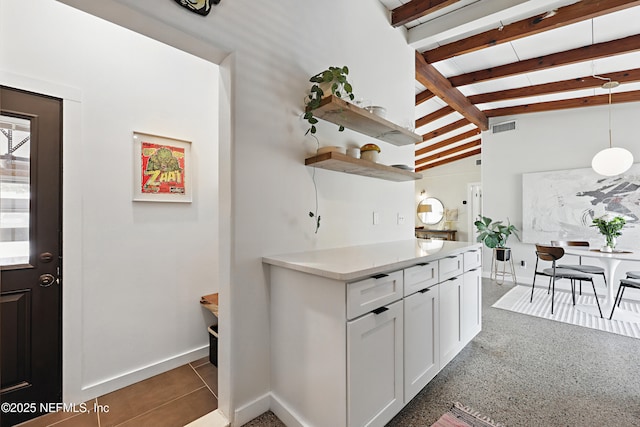 kitchen featuring white cabinetry, hanging light fixtures, and vaulted ceiling with beams