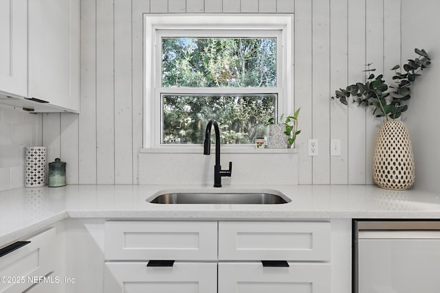 kitchen featuring white cabinetry, light stone countertops, sink, and backsplash