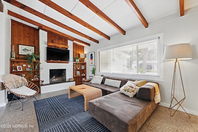 living room featuring wooden walls, a fireplace, and beam ceiling