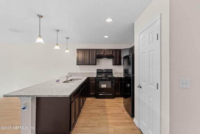 kitchen with sink, decorative light fixtures, kitchen peninsula, light hardwood / wood-style floors, and black appliances