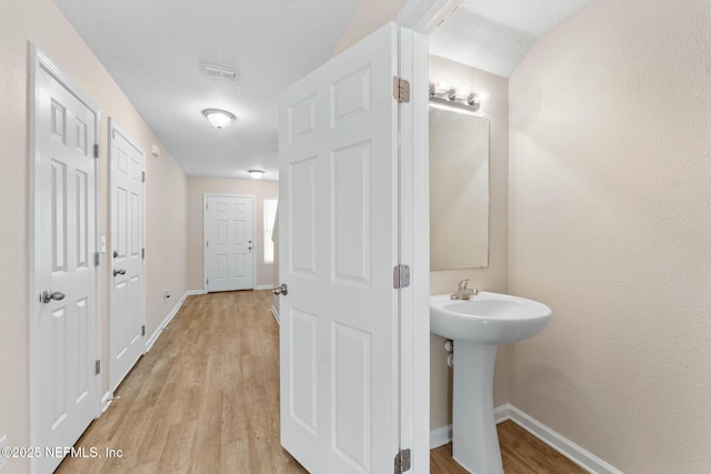 bathroom with hardwood / wood-style floors and a textured ceiling