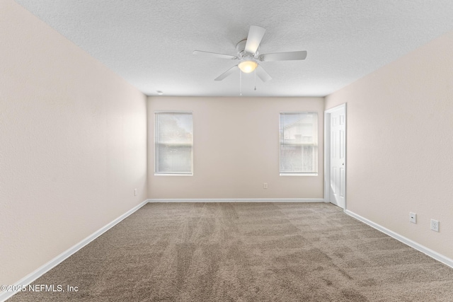 unfurnished room featuring carpet floors, a textured ceiling, and a wealth of natural light