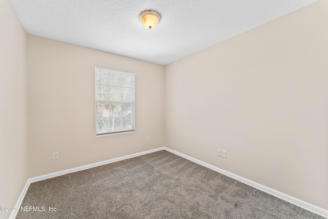 carpeted spare room with a textured ceiling