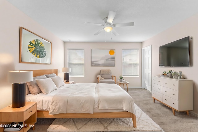 bedroom with multiple windows, light colored carpet, and ceiling fan