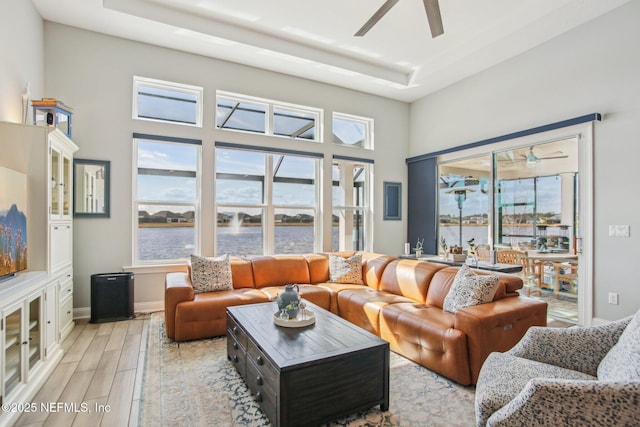 living room featuring a water view and ceiling fan