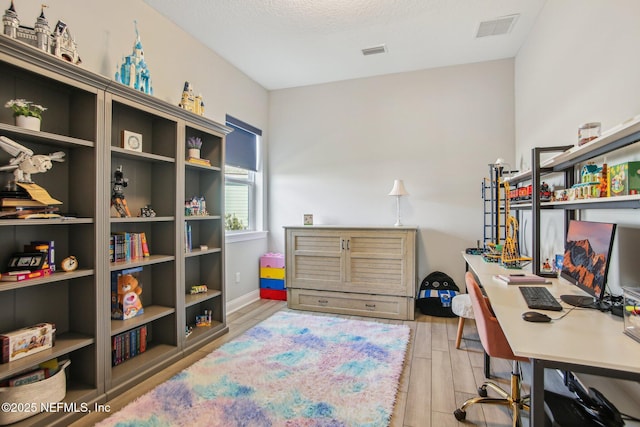 office space with a textured ceiling and light hardwood / wood-style floors