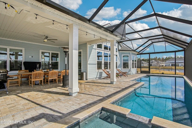 view of swimming pool with ceiling fan, a lanai, and a patio