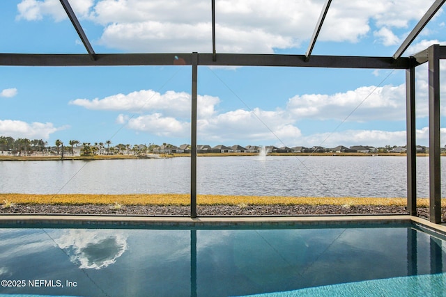 view of pool with glass enclosure and a water view