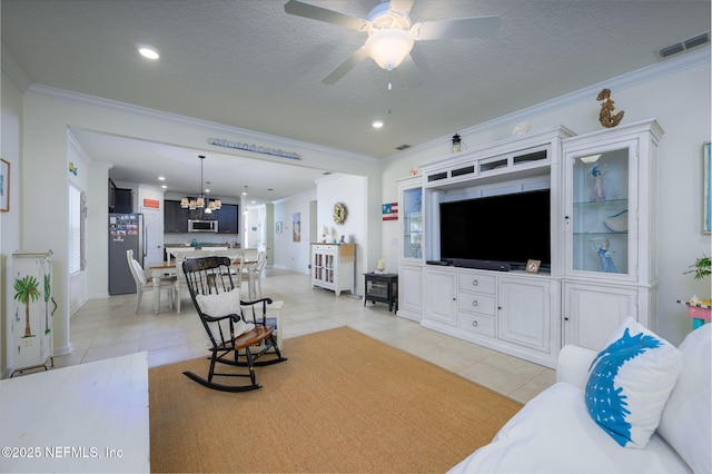 tiled living room featuring ornamental molding, ceiling fan with notable chandelier, and a textured ceiling