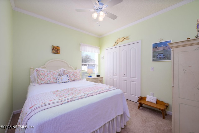 carpeted bedroom featuring ornamental molding, ceiling fan, and a closet