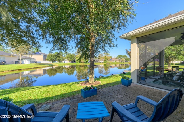 view of patio featuring a water view and a sunroom