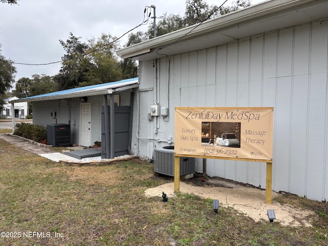 view of side of property with a yard and central air condition unit