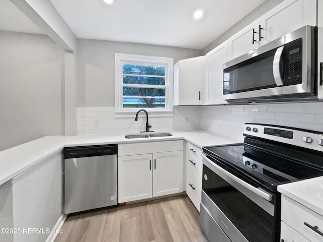 kitchen with sink, white cabinets, and appliances with stainless steel finishes