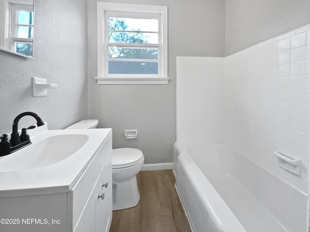 full bathroom with vanity, hardwood / wood-style floors, shower / bathtub combination, and toilet