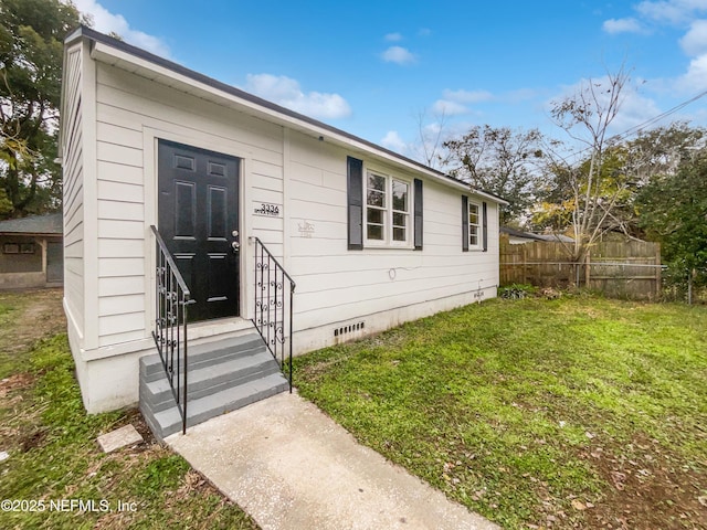 entrance to property with a lawn