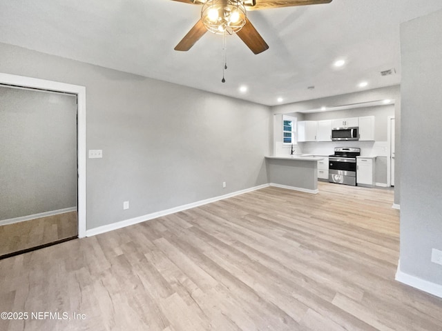 unfurnished living room featuring ceiling fan, sink, and light wood-type flooring