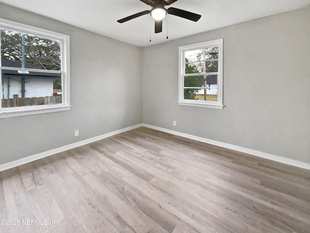 empty room with ceiling fan and light hardwood / wood-style flooring