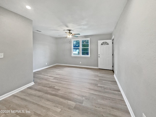 spare room with ceiling fan and light wood-type flooring