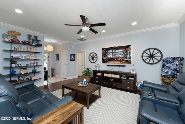 living room featuring crown molding, ceiling fan, hardwood / wood-style flooring, and a textured ceiling