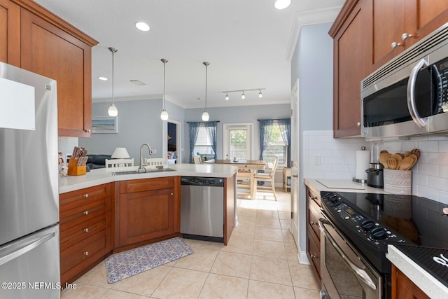 kitchen with pendant lighting, sink, backsplash, stainless steel appliances, and ornamental molding