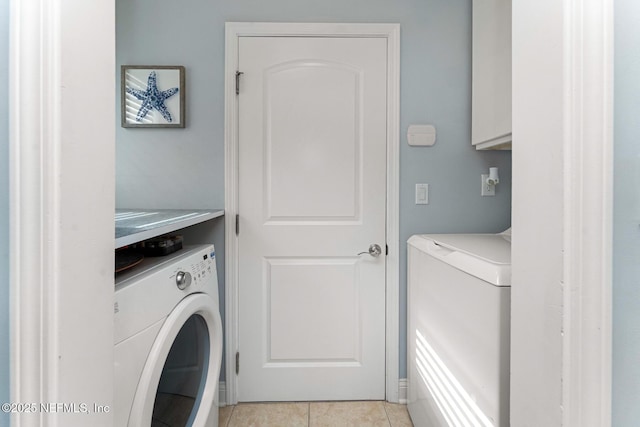 laundry area with cabinets, washer and dryer, and light tile patterned floors