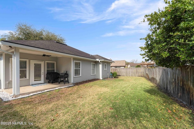 view of yard featuring ceiling fan and a patio