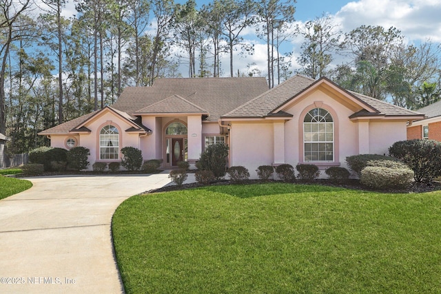 view of front of home featuring driveway, a front lawn, and stucco siding