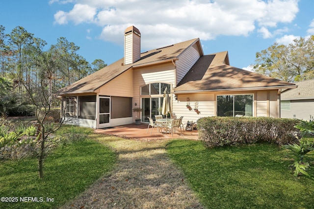 rear view of house with a yard, a sunroom, and a patio