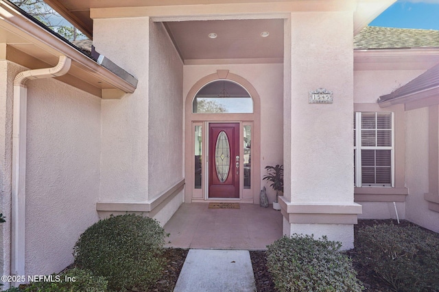 doorway to property featuring stucco siding