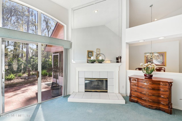 living room with a fireplace, high vaulted ceiling, a chandelier, and carpet flooring