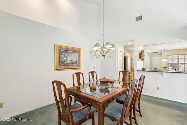 dining area with dark colored carpet, a towering ceiling, visible vents, and baseboards