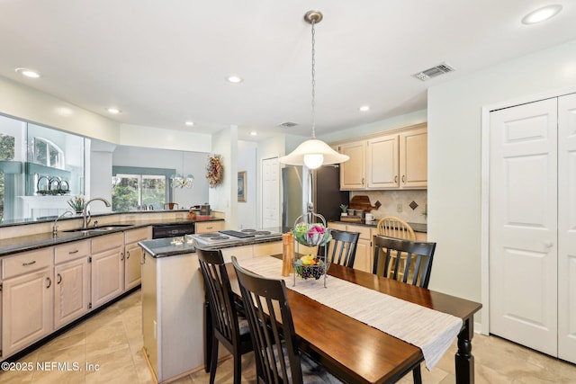 kitchen with sink, stainless steel refrigerator, tasteful backsplash, decorative light fixtures, and kitchen peninsula