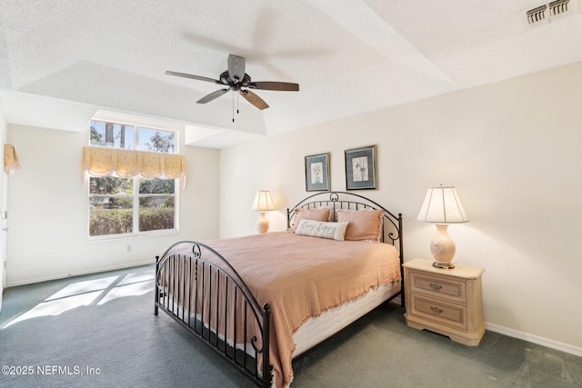 carpeted bedroom featuring a ceiling fan, visible vents, a textured ceiling, and baseboards