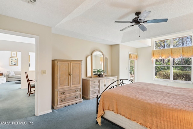 carpeted bedroom with a ceiling fan, a textured ceiling, and baseboards