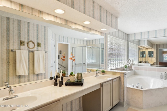 full bath with wallpapered walls, a textured ceiling, a sink, and a stall shower