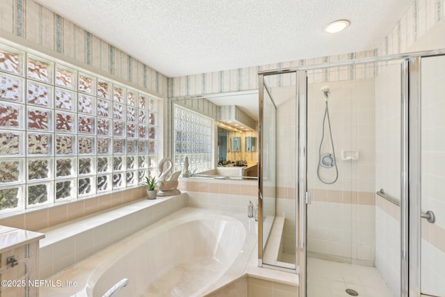 bathroom with a textured ceiling, a stall shower, a garden tub, and wallpapered walls