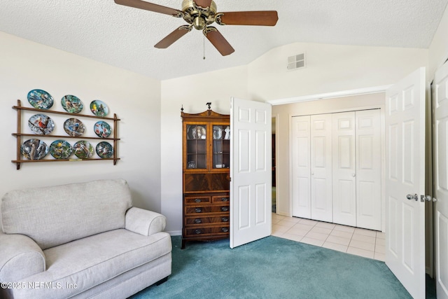 sitting room featuring light tile patterned floors, visible vents, light carpet, vaulted ceiling, and a textured ceiling