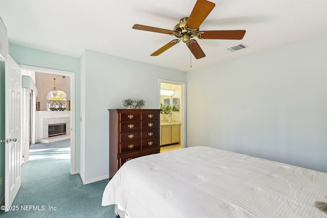 carpeted bedroom featuring a fireplace and ceiling fan