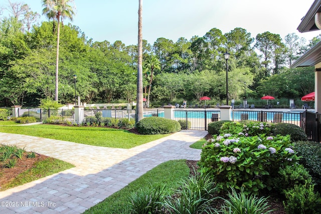 pool featuring fence and a lawn