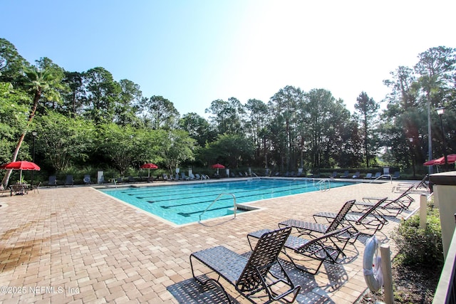 pool with a patio area and fence