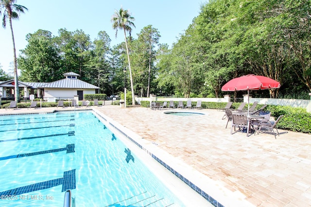 pool with a patio area and fence