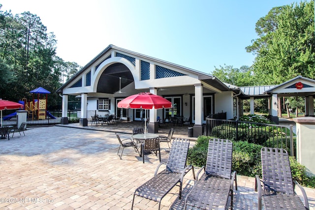 exterior space featuring metal roof, fence, playground community, a patio area, and stucco siding