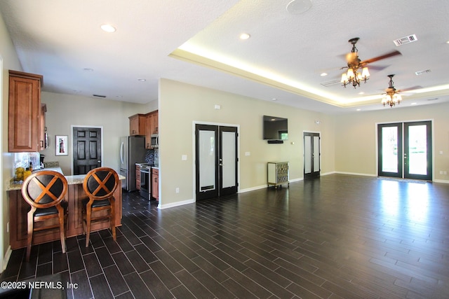 interior space featuring dark wood-style flooring, visible vents, baseboards, french doors, and a raised ceiling