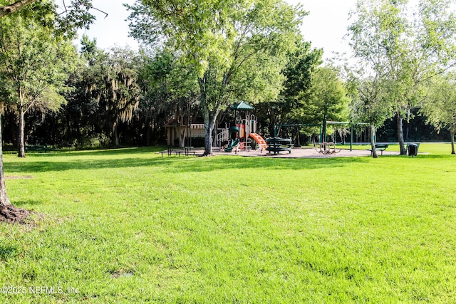 view of home's community with playground community and a yard